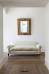Beige sofa in a room with a decorative mirror on the wall, featuring the brand 'Dunlin'.