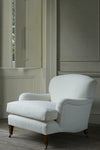 White armchair in a room with neutral walls and wooden floor.