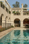Pool at Arent & Pyke Hawthorn House with Dunlin Decade Lights. Hurricane Rattan Lantern and Claude Wall Lights