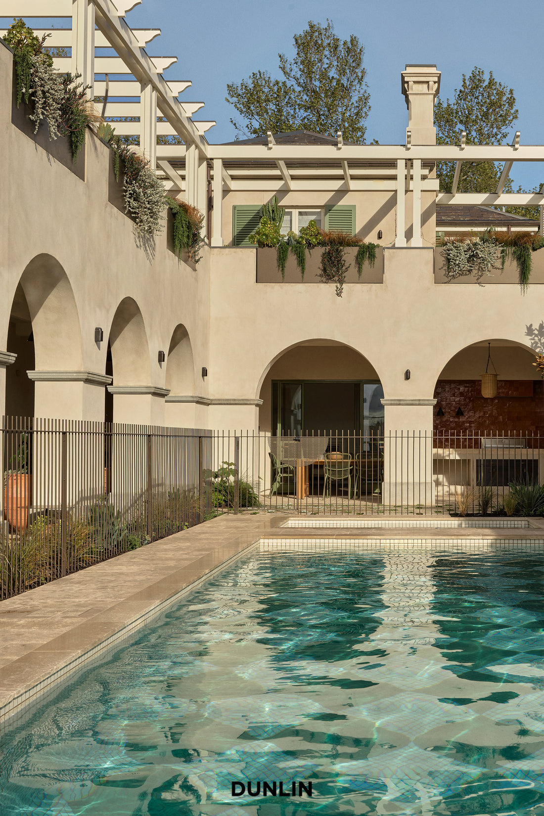 Pool at Arent & Pyke Hawthorn House with Dunlin Decade Lights. Hurricane Rattan Lantern and Claude Wall Lights
