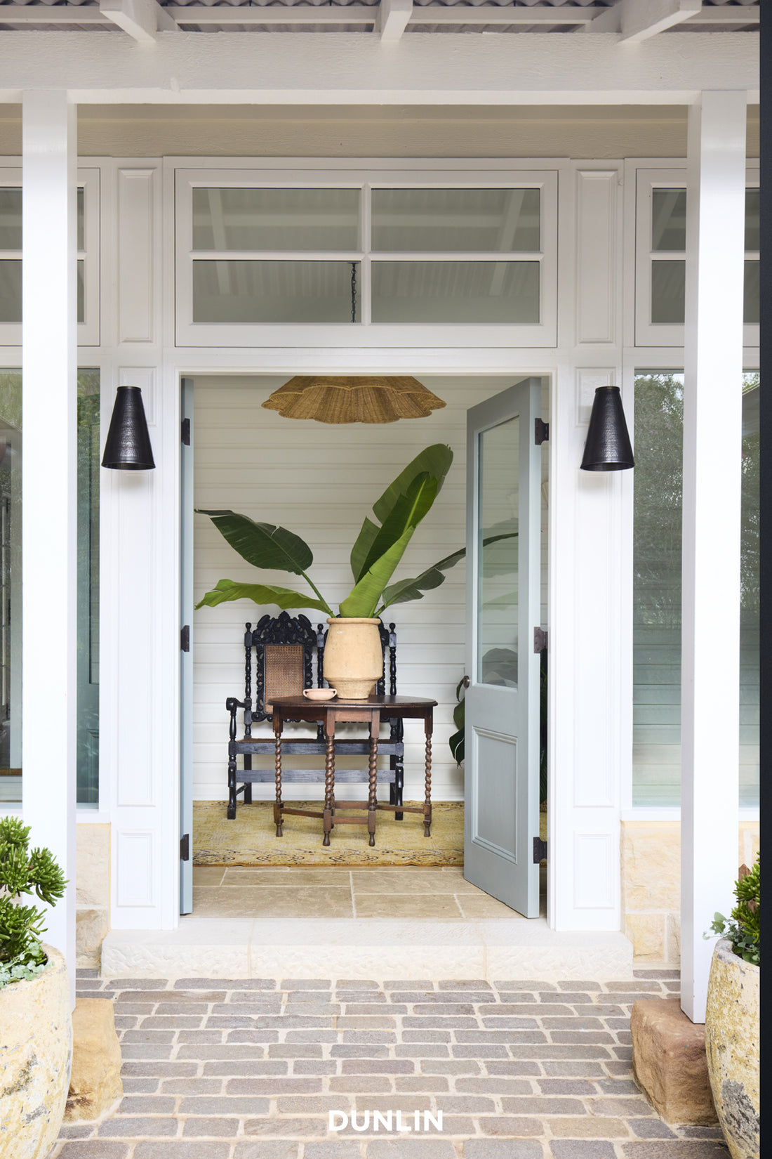 Front door of a house with a plant and chair inside, featuring the brand 'Dunlin'.