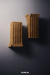 Two Dunlin Filippo rattan wall sconces mounted on a dark wall, with a visible Dunlin logo at the bottom. DUNLIN Rattan UP down lights 