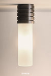 A cylindrical ceiling light with a weathered brass finish and frosted cover, branded by DUNLIN.