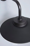 Close-up of a black metal lamp shade and curved stem with the brand name DUNLIN at the bottom.